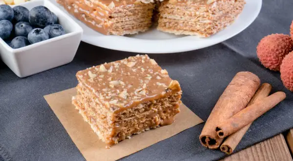 Pyszne wafle z kajmakiem, posypane orzechami, obok jagody, liczi i laski cynamonu.