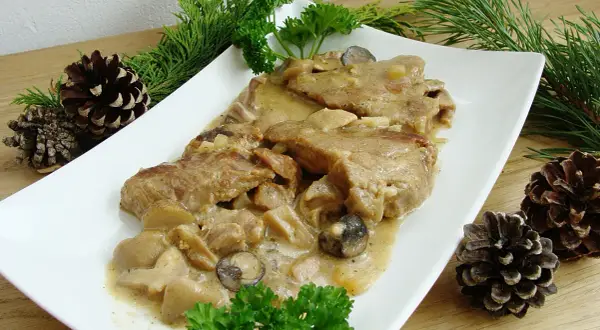 Karkówka w sosie grzybowym, podana z gałązkami iglaków i szyszkami, wygląda apetycznie.