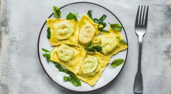 Pyszne ravioli z zielonym nadzieniem, udekorowane listkami. Idealny przepis na obiad.