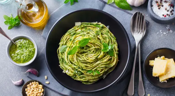 Pyszny piątkowy obiad bez mięsa: spaghetti z pesto, świeżą bazylią, orzeszkami pinii i parmezanem. Idealny na lekki posiłek.