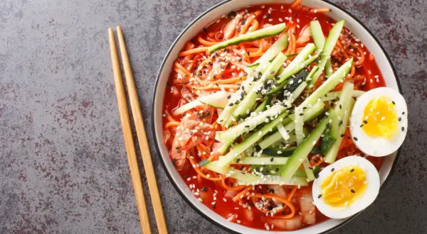 Pyszne koreańskie noodle w pikantnym sosie, z ogórkiem, jajkiem i sezamem. Idealne na szybki posiłek.