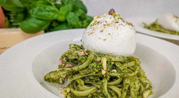 Makaron z pesto pistacjowym i burratą, posypany posiekanymi pistacjami. Pyszne danie, które zachwyca smakiem i wyglądem.