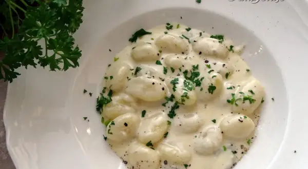 Puszyste gnocchi z gorgonzolą w kremowym sosie, posypane świeżą natką pietruszki. Idealne danie dla miłośników włoskich smaków.