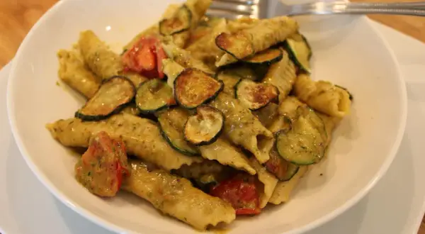 Pyszne makaron garganelli z cukinią i pomidorkami w sosie pesto.