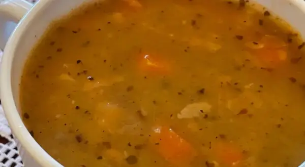 Gęsta, aromatyczna grochówka wege z kawałkami marchewki i przyprawami w białej miseczce.