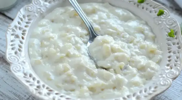 Pyszna, kremowa zupa mleczna z ryżem, podana w ozdobnej miseczce. Idealna na śniadanie lub deser.