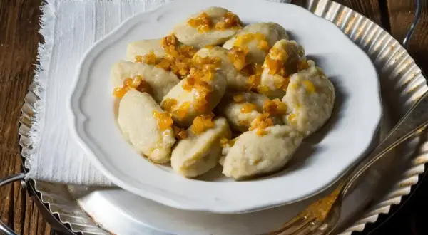Pyszne kluski śląskie z okrasą, idealne na obiad. Czas gotowania pierogów to chwila, ale te kluski to prawdziwy przysmak!