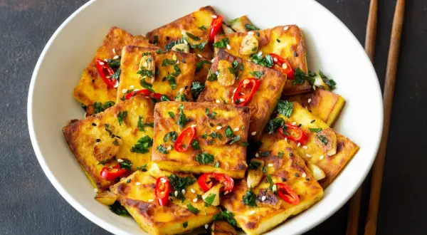 Złocisty, chrupiący tofu zmieniające życie, posypane chili, czosnkiem i sezamem. Pyszne danie, które odmieni Twoje spojrzenie na roślinne jedzenie.