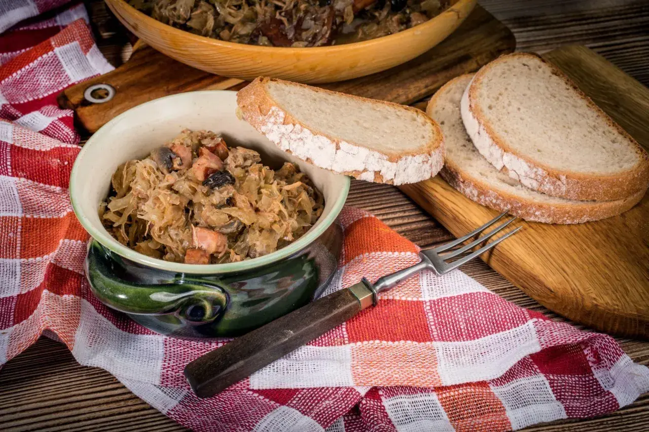 Tradycyjny bigos babci, pachnący kapustą i mięsem, podany z chlebem. Idealny przepis na polskie danie.