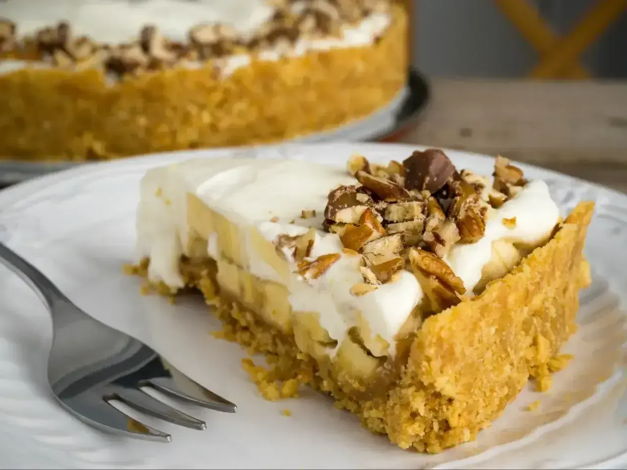 Pyszny kawałek fit banoffee z bananami, bitą śmietaną i orzechami. Idealny deser dla dbających o linię.