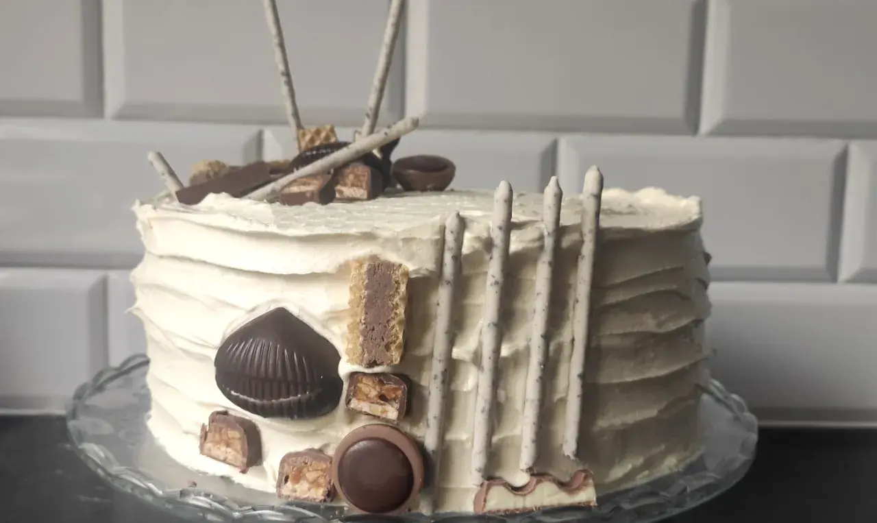 Pyszny tort z chrupką, udekorowany batonikami, czekoladkami i wafelkami. Idealny na każdą okazję!