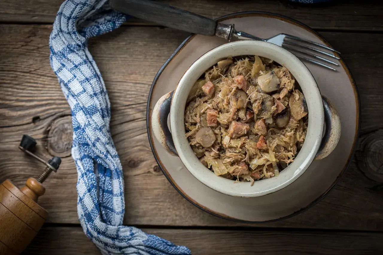 Tradycyjny bigos w glinianym naczyniu, gotowy do podania. Idealny na zimę, a ile gotować bigos, by był pyszny? Długo!