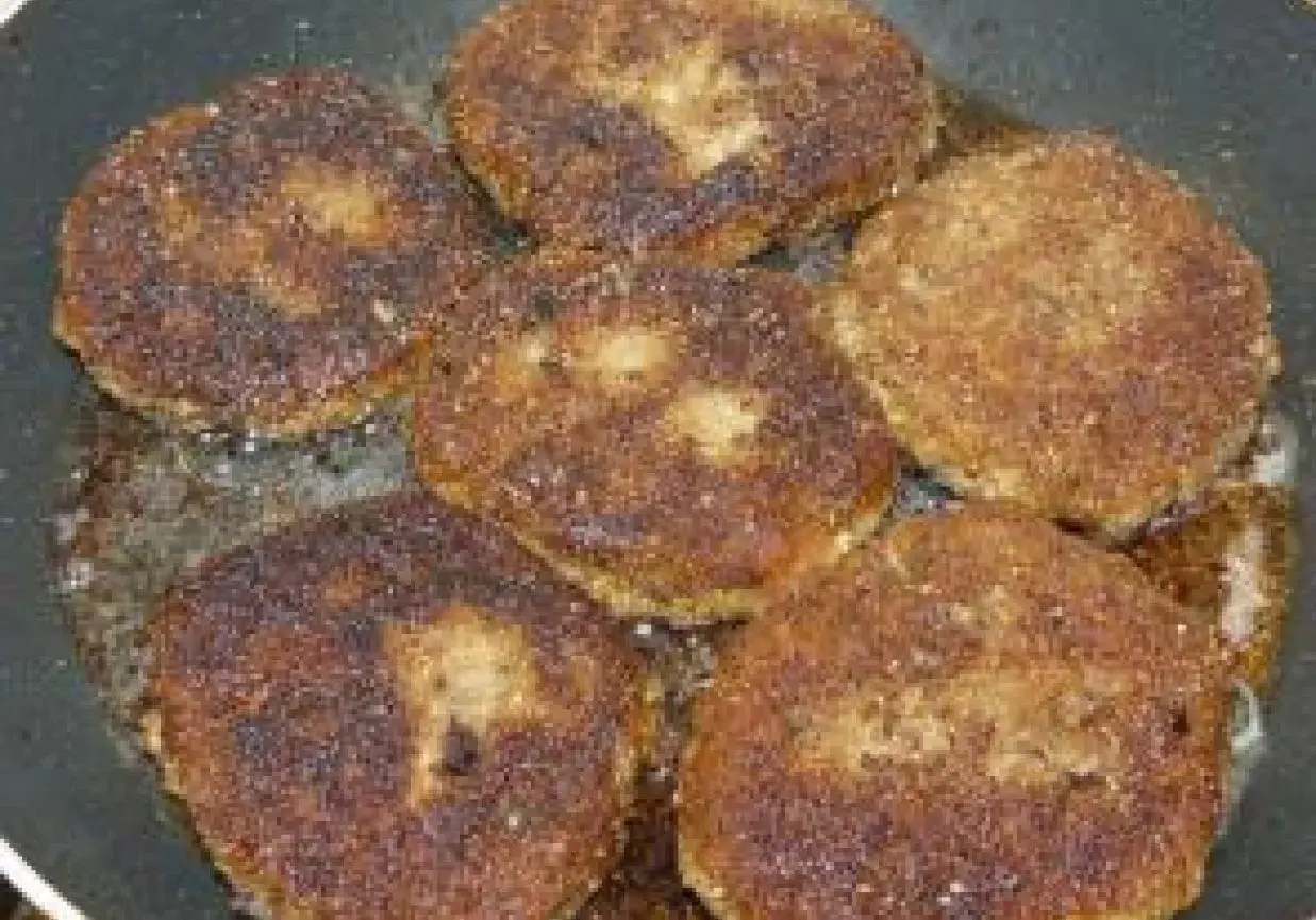 Smażone kotlety z grzybów w panierce, rumiane i apetyczne, skwierczą na patelni.