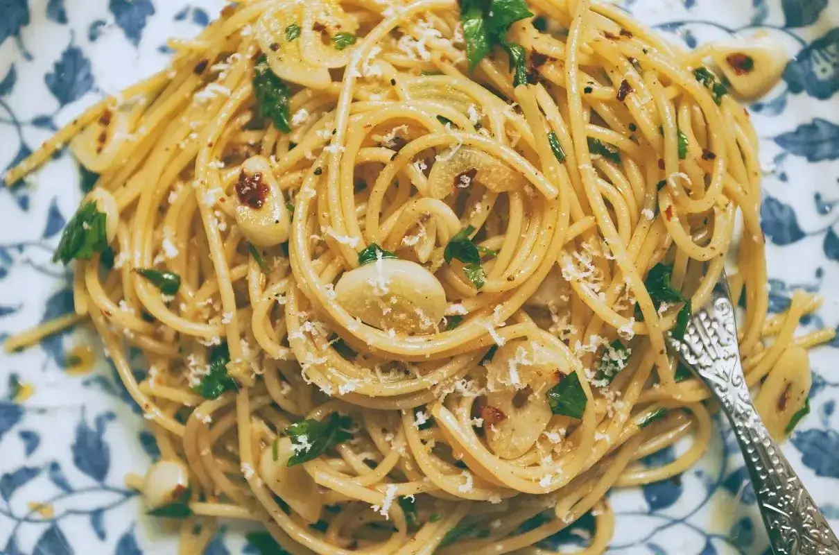 Pyszny makaron z oliwą i czosnkiem, posypany parmezanem i natką pietruszki. Idealny na szybki obiad.