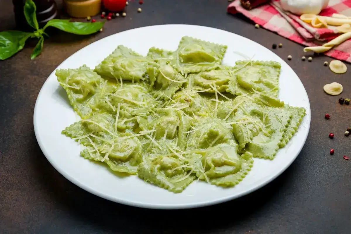 Pyszne ravioli ze szpinakiem i ricottą, polane kremowym sosem i posypane parmezanem. Idealne na lekki obiad.