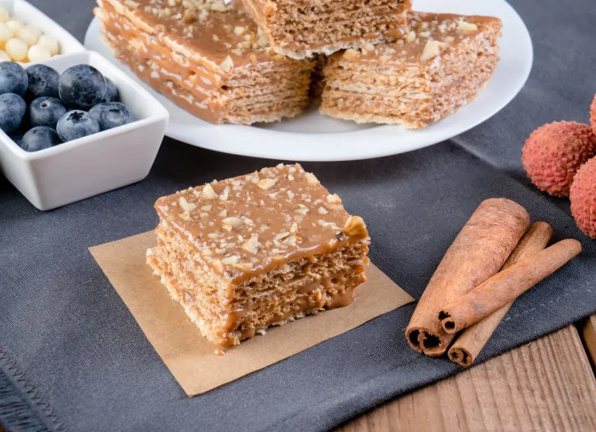 Pyszne wafle z kajmakiem, posypane orzechami, obok jagody, liczi i laski cynamonu.