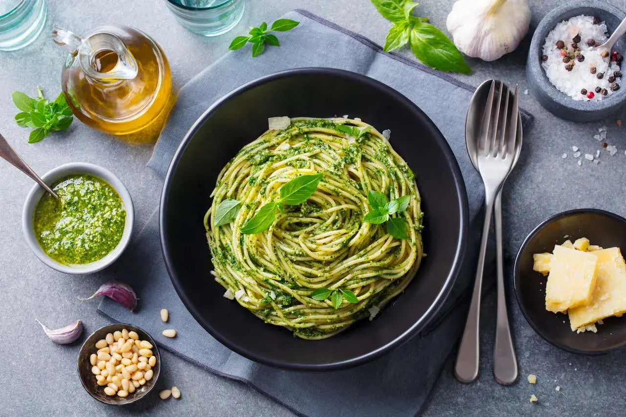 Pyszny piątkowy obiad bez mięsa: spaghetti z pesto, świeżą bazylią, orzeszkami pinii i parmezanem. Idealny na lekki posiłek.
