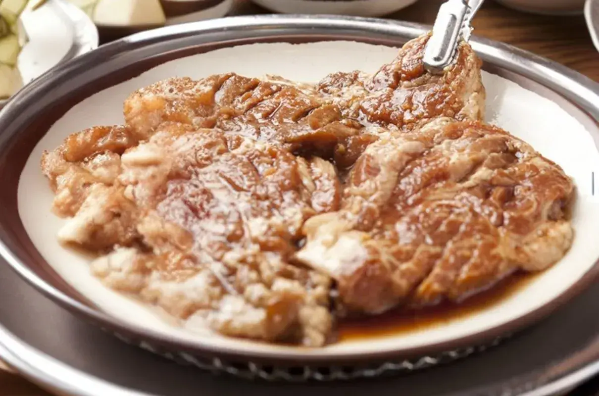 Soczyste skrzydełka w miodzie, gotowe do grillowania. Mięso jest błyszczące od marynaty, zapowiada się pyszny posiłek.