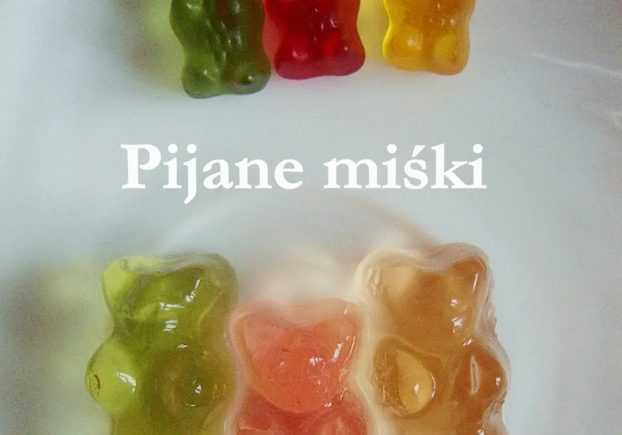 Kolorowe żelki z alkoholem w kształcie misiów, niektóre lekko rozpuszczone, tworzą słodką i odurzającą kompozycję.
