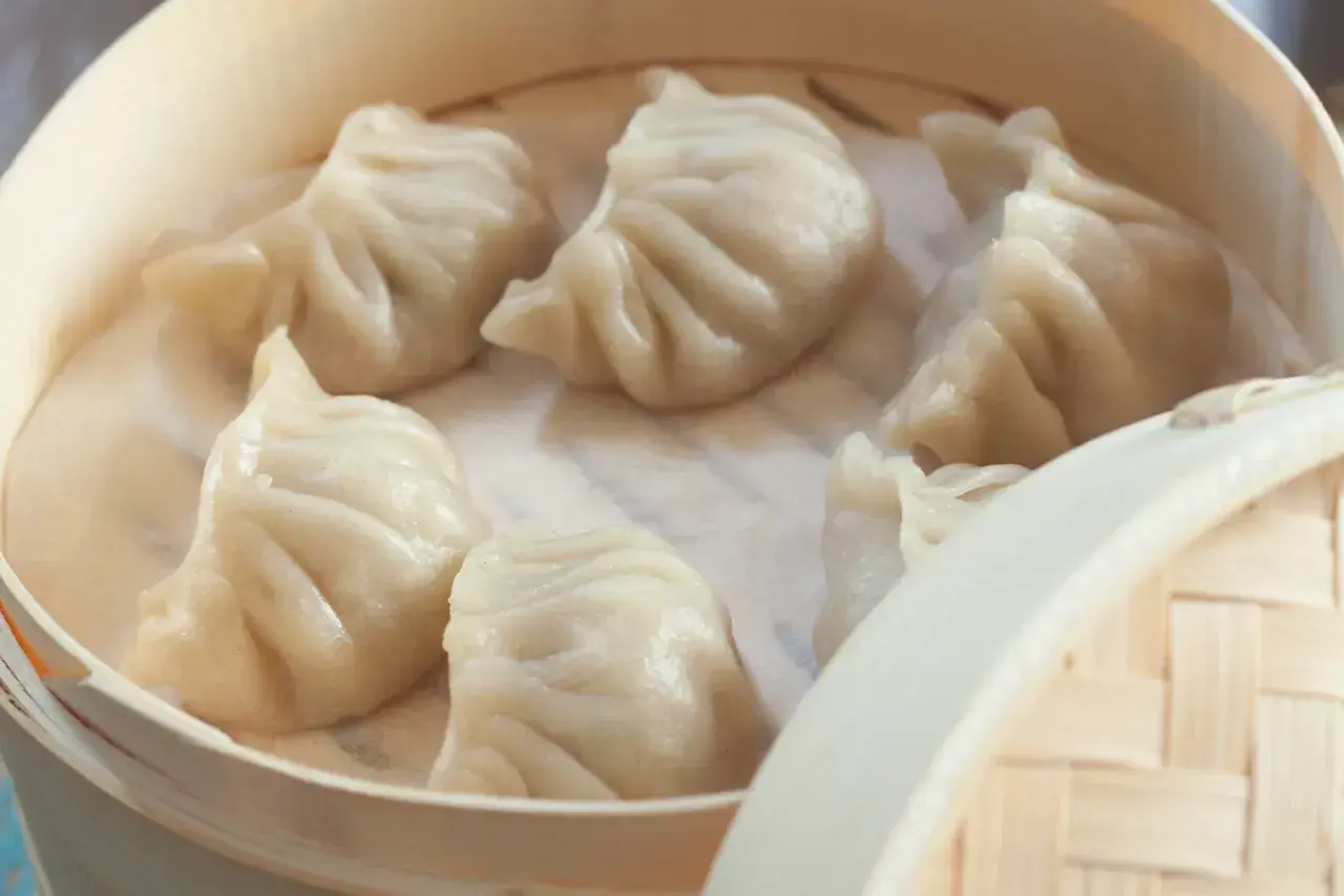 Pyszne pierożki na parze w bambusowym parowniku, gotowe do podania.
