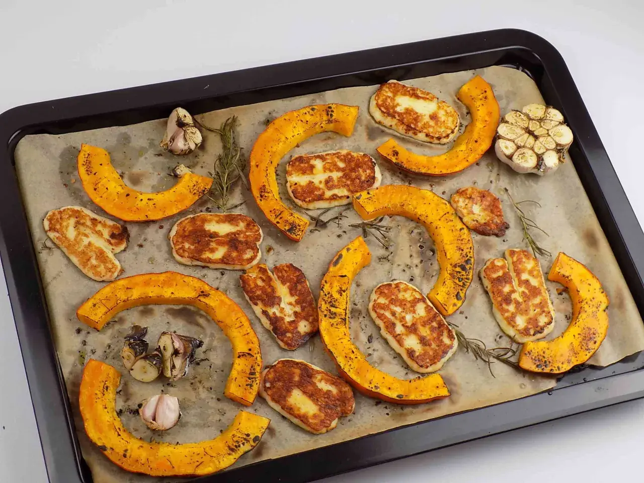 Pieczona dynia piżmowa z serem halloumi i czosnkiem na blasze.
