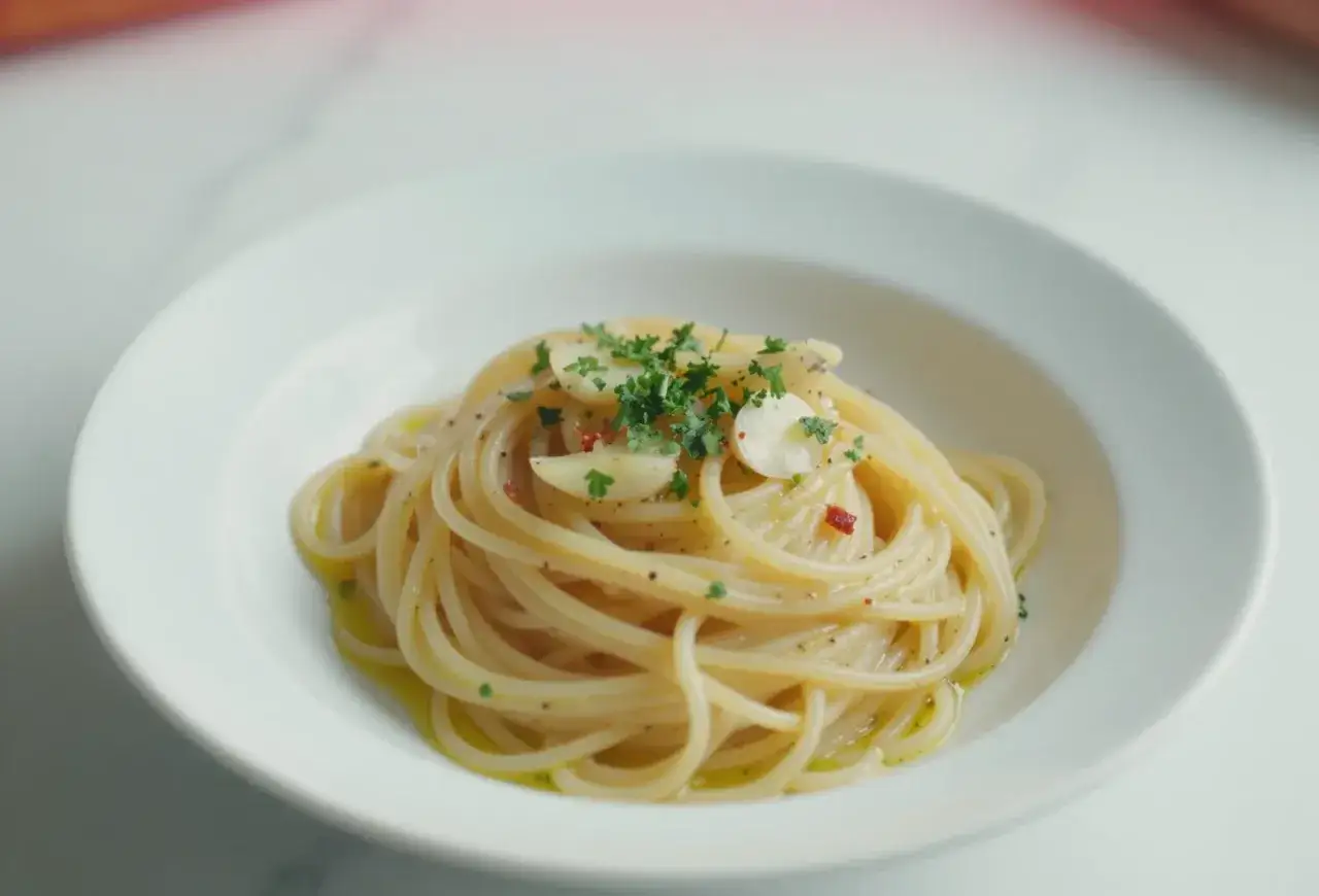 Spaghetti aglio olio z czosnkiem, natką pietruszki i płatkami chili, polane oliwą.