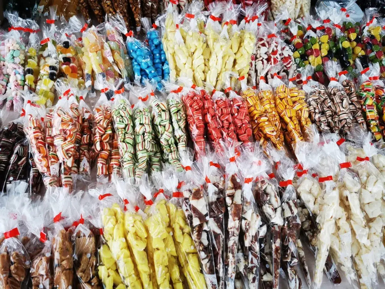 Kolorowe cukierki i słodkości, jak trupi miodek, w paczuszkach.