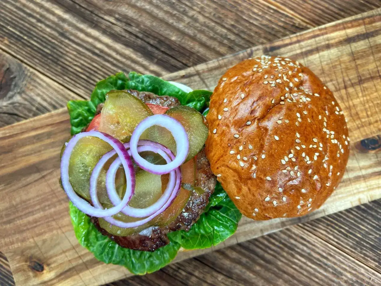 Pyszny burger z soczystą wołowiną, chrupiącą sałatą, ogórkiem i cebulą. Idealny przepis na to, jak smażyć burgera.