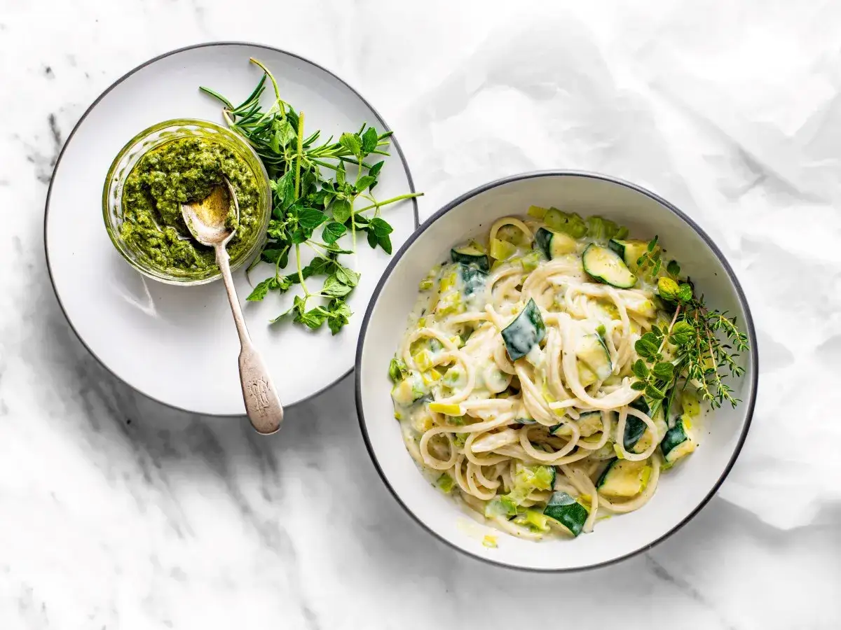 Pyszny makaron z cukinią w kremowym sosie, podany z pesto i świeżymi ziołami.