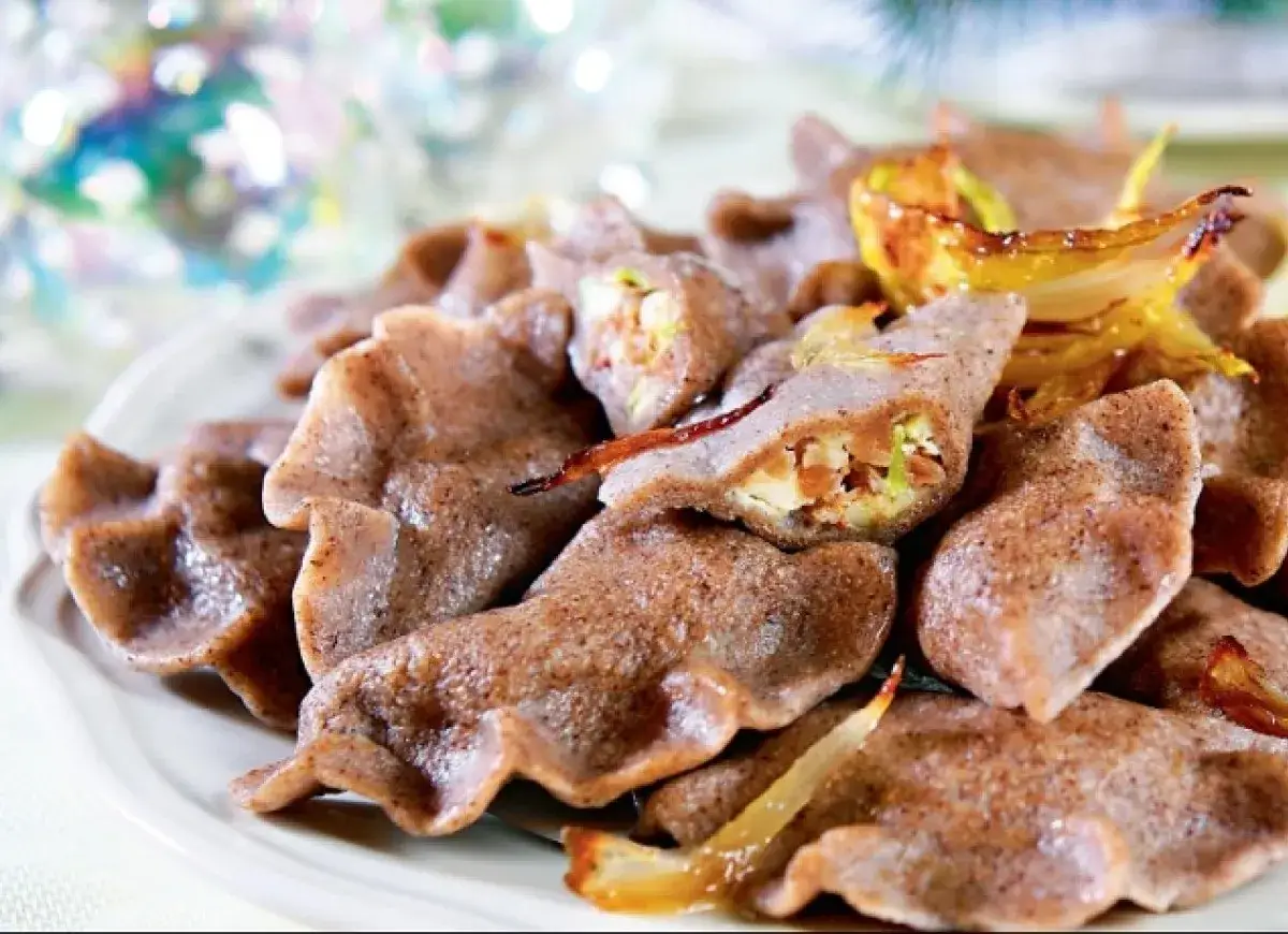 Pyszne pierogi z tofu, z farszem z warzyw i podsmażoną cebulką, na talerzu.