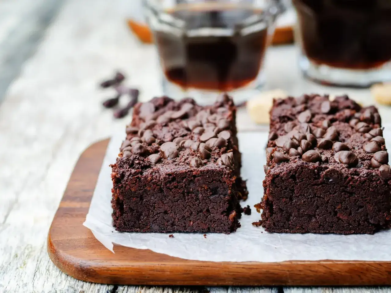 Dwa pyszne, wilgotne fit brownie z fasoli, posypane czekoladowymi kawałkami, idealne na zdrowy deser.