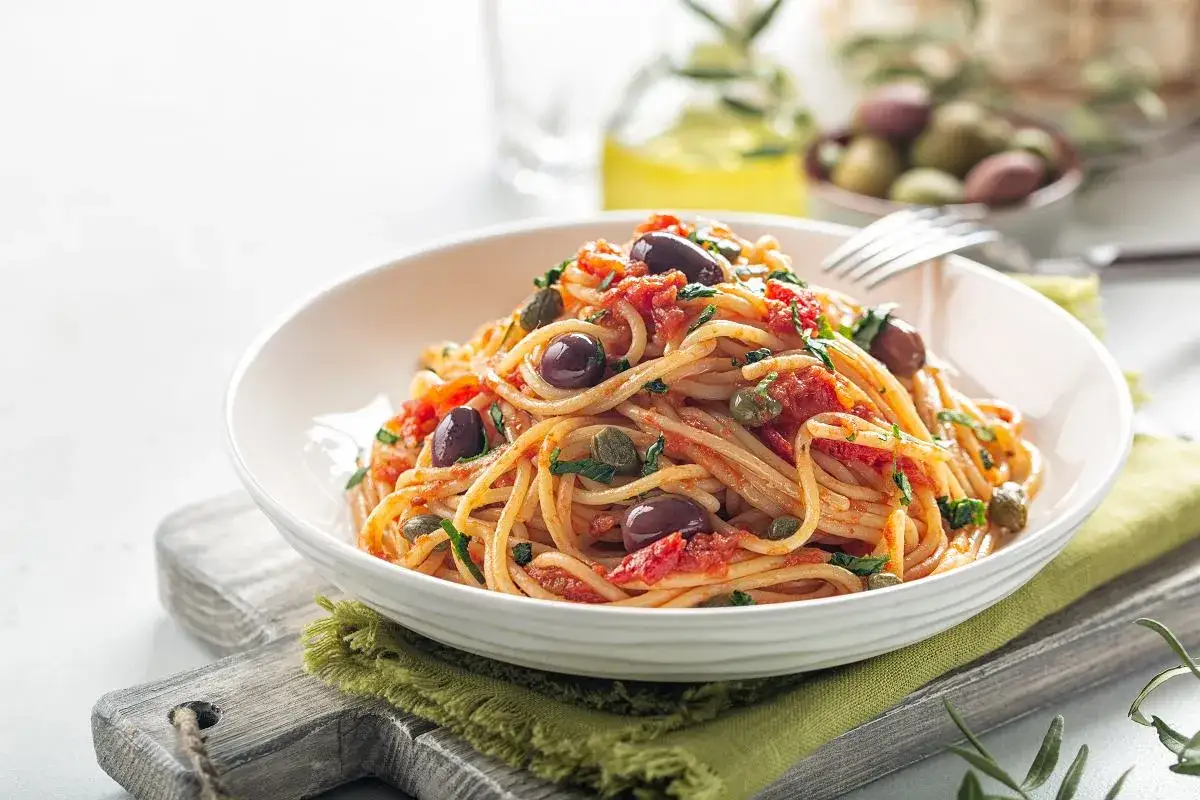 Pyszne spaghetti z sosem pomidorowym, oliwkami i kaparami. Idealne danie, by pokazać, co można zjeść z makaronem.