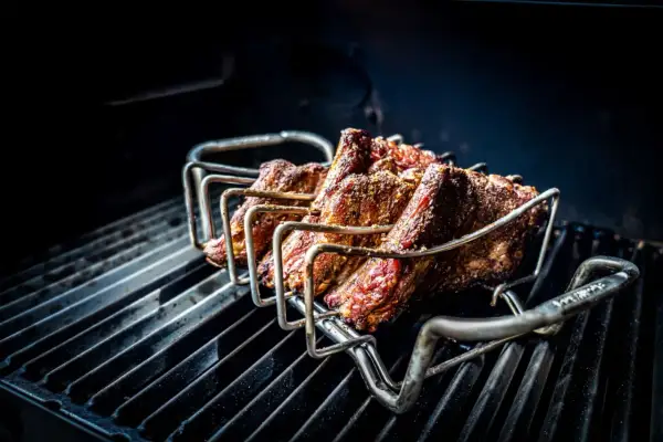 Żeberka w stojaku na grillu, gotowe na prawdziwy barbecue po polsku. Soczyste mięso pieczone na ruszcie.
