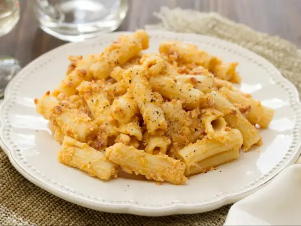 Penne po włosku z kremowym sosem i kawałkami boczku, posypane parmezanem i pieprzem.