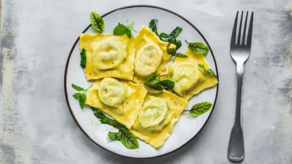 Pyszne ravioli z zielonym nadzieniem, udekorowane listkami. Idealny przepis na obiad.