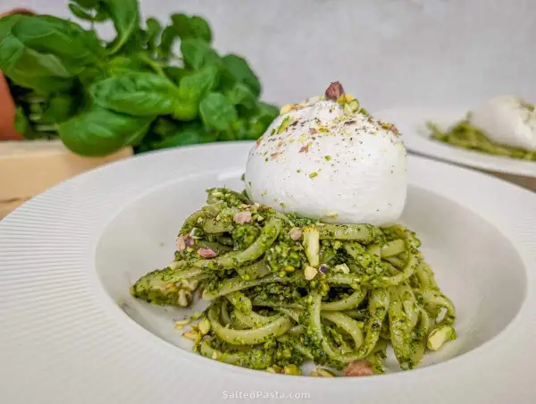 Makaron z pesto pistacjowym i burratą, posypany posiekanymi pistacjami. Pyszne danie, które zachwyca smakiem i wyglądem.