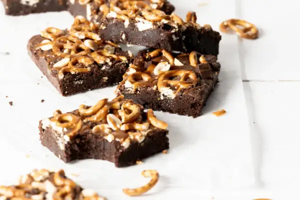 Czekoladowe brownie z karmelem i orzechami, posypane kawałkami precelków. Pyszna przekąska.