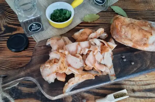 Pokrojone, przyprawione mięso na kebaba leży na drewnianej desce obok przypraw i ziół.