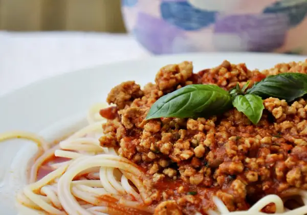 Pyszne spaghetti bolognese z pomidorów, z aromatycznym mięsem mielonym i świeżą bazylią. Idealne na obiad.